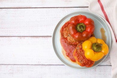 Photo of Delicious stuffed bell peppers on white wooden table, top view. Space for text