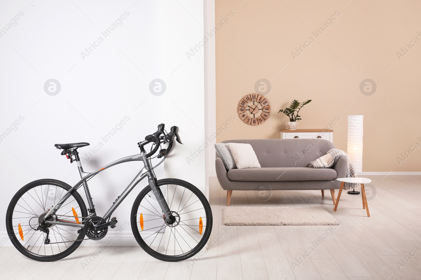 Photo of Modern apartment interior with bicycle near wall. Space for text