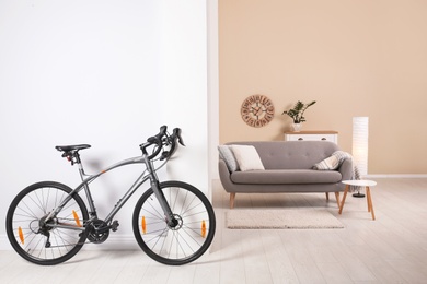 Modern apartment interior with bicycle near wall. Space for text