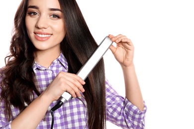 Happy woman using hair iron on white background