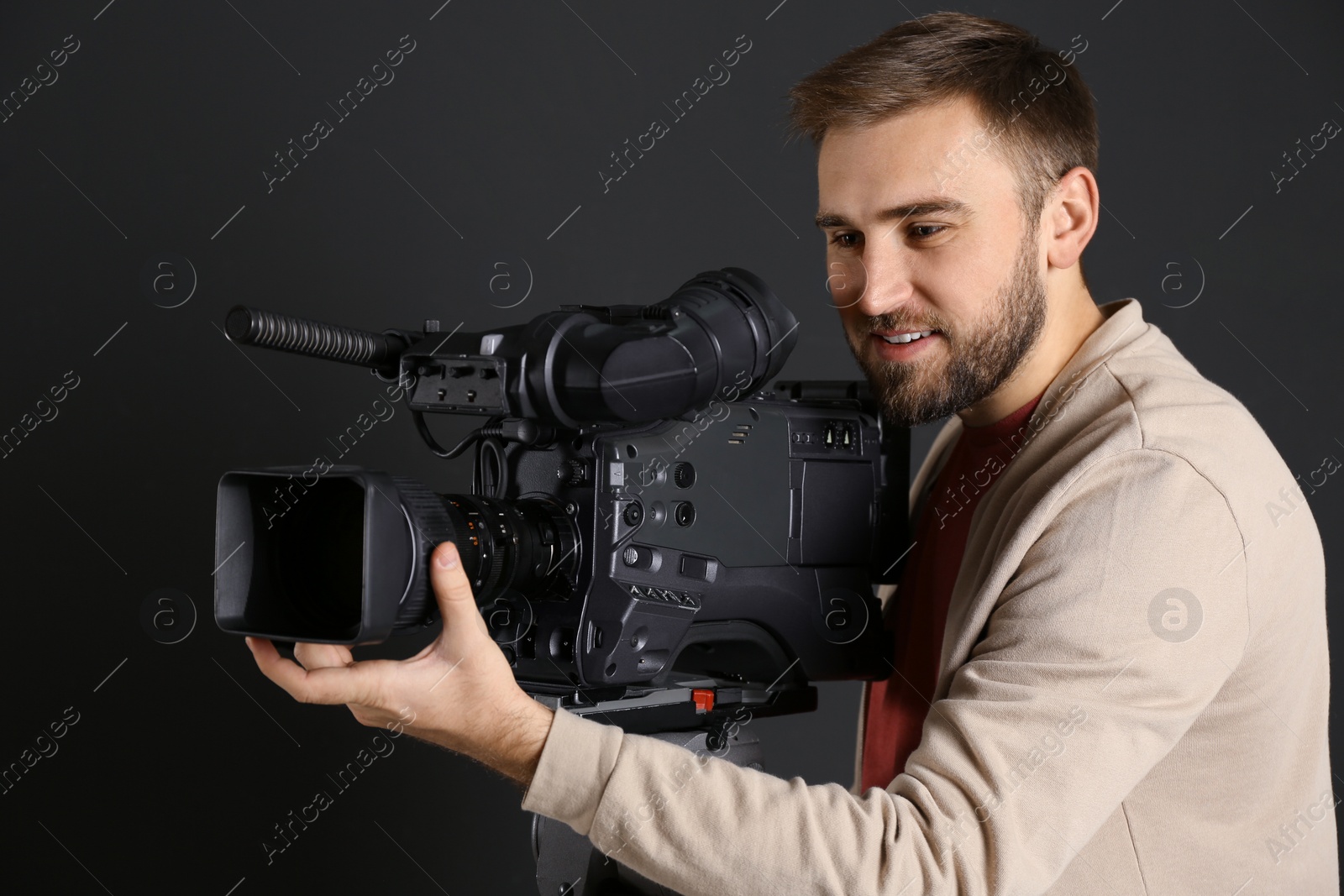 Photo of Operator with professional video camera on black background