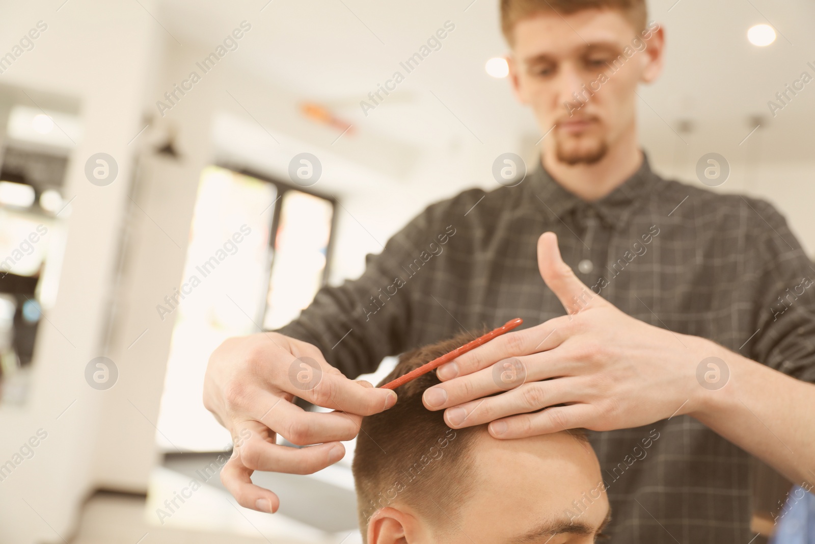 Photo of Professional barber working with client in hairdressing salon. Hipster fashion