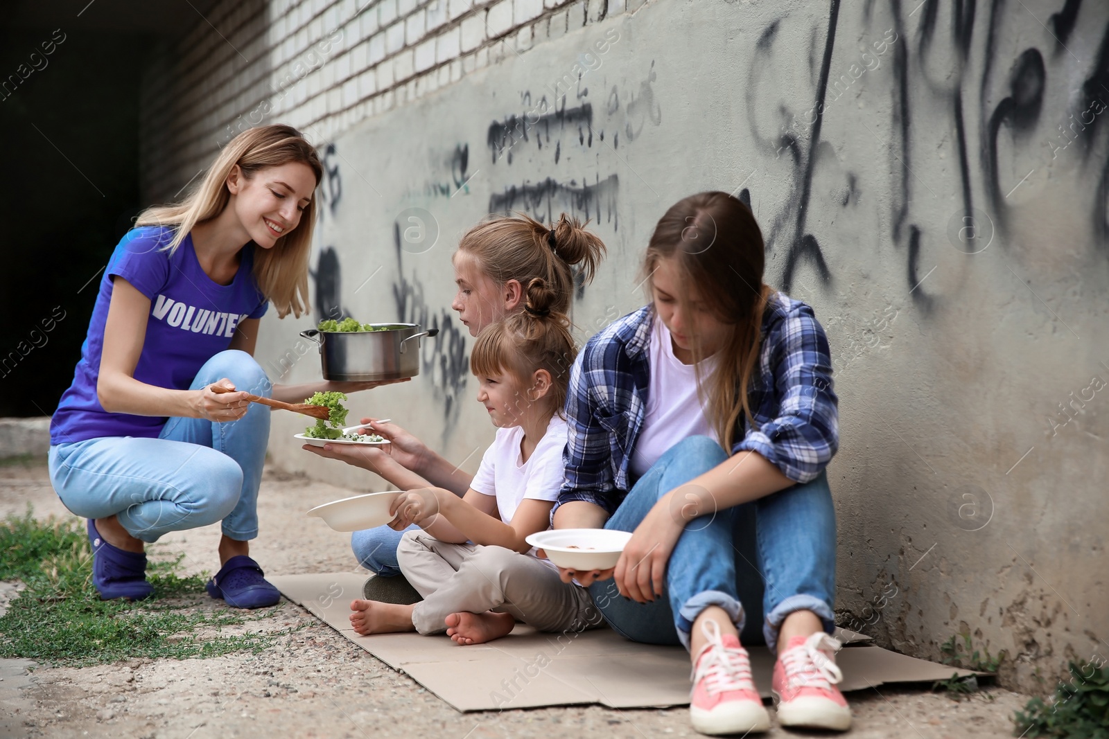 Photo of Poor people receiving food from volunteer outdoors