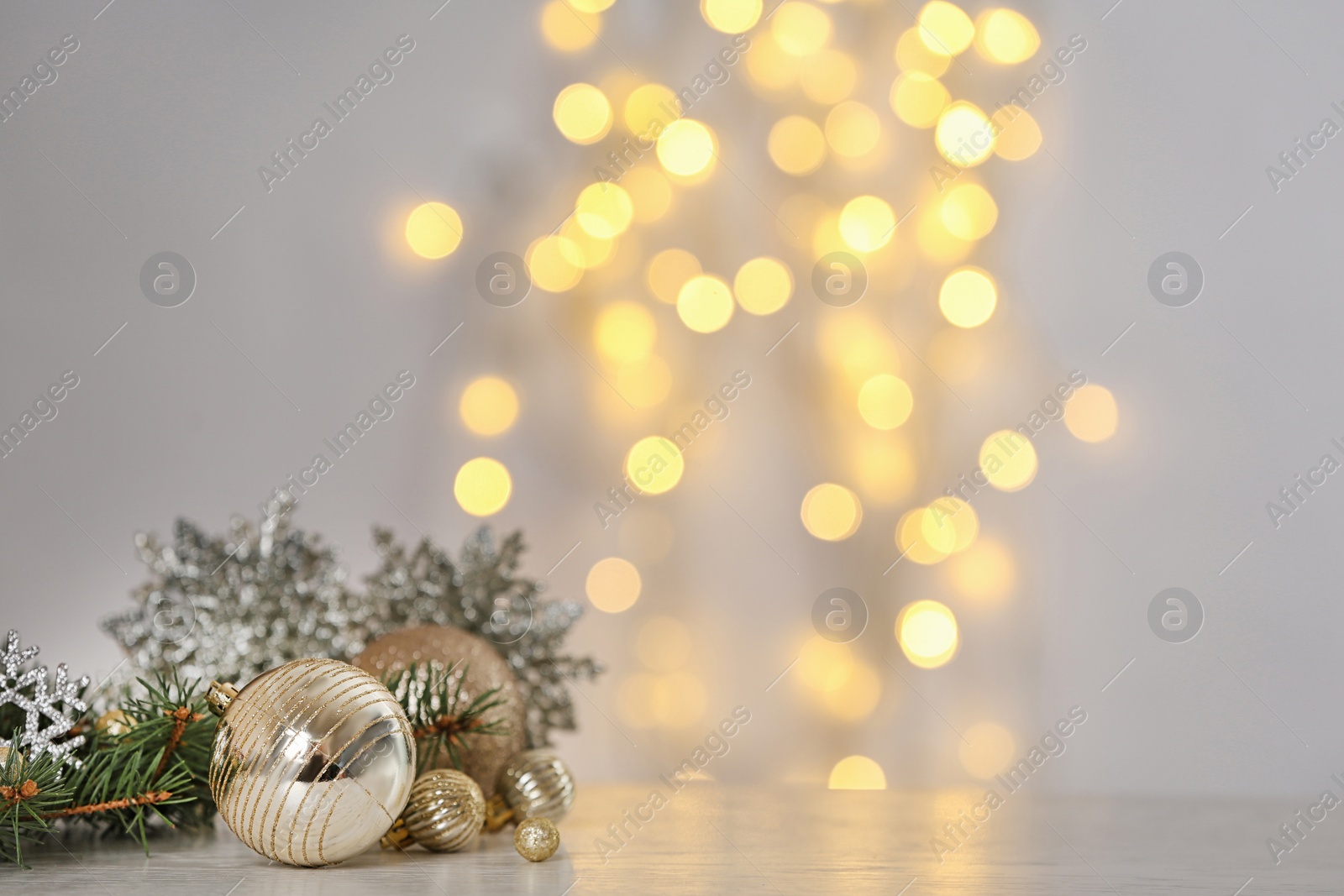 Photo of Christmas decoration on table against blurred lights. Space for text