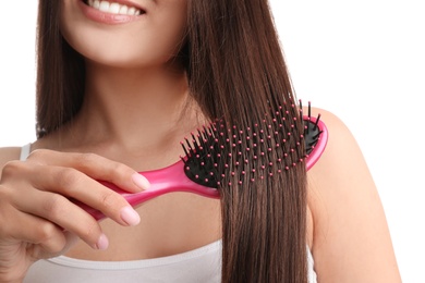 Woman with hair brush on white background, closeup