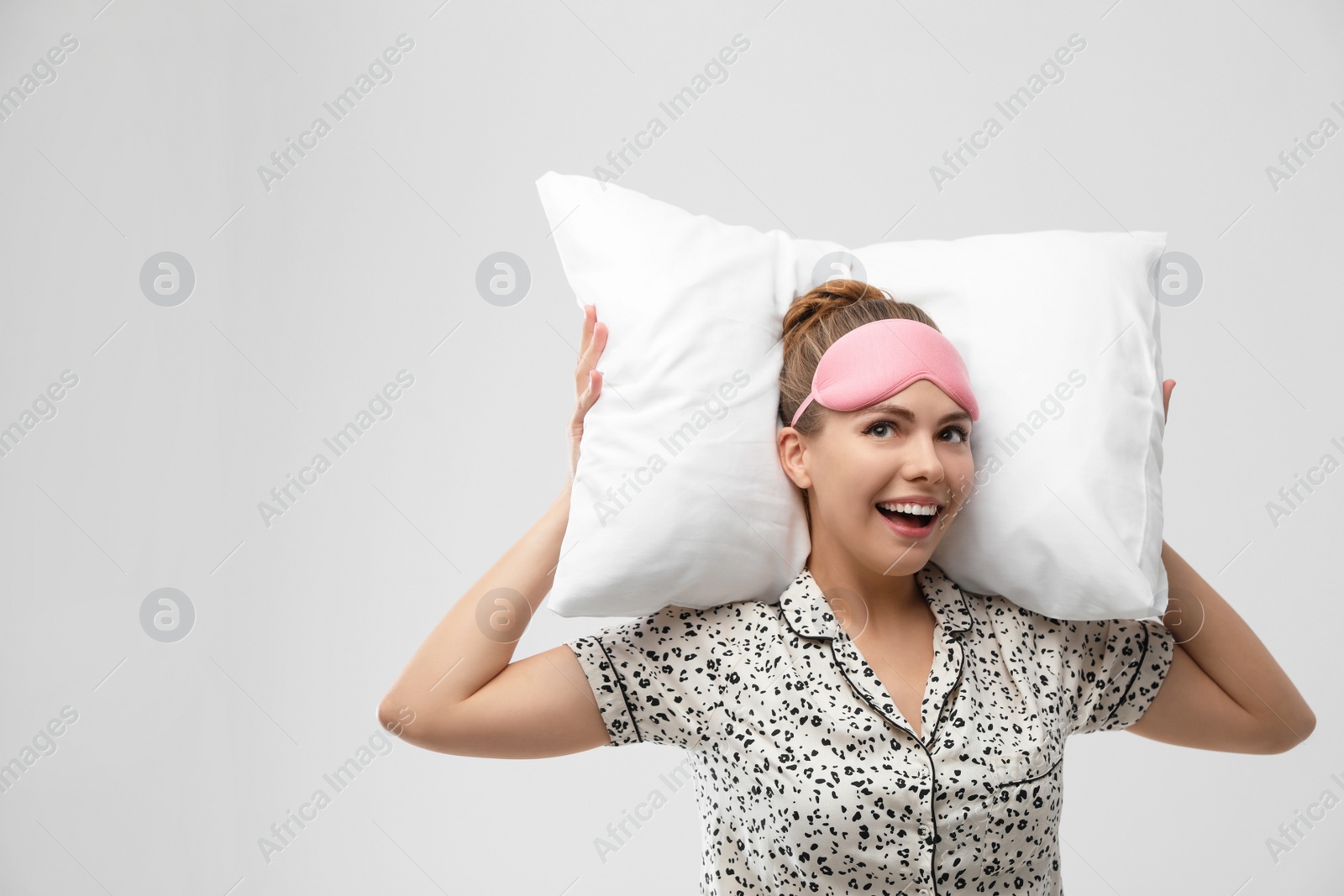 Photo of Beautiful woman with pillow on light grey background. Bedtime