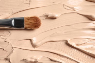 Photo of Sample of skin foundation and makeup brush, closeup