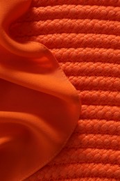 Photo of Orange fabric on wicker mat, top view