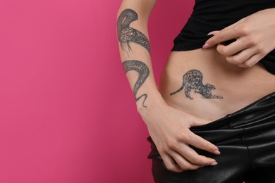 Photo of Woman with tattoos on body against pink background, closeup. Space for text