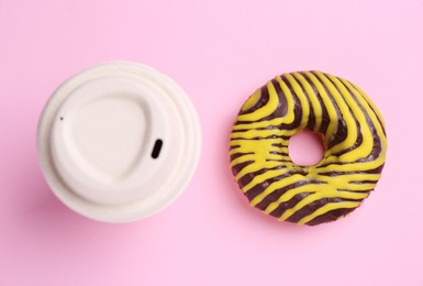 Tasty donut and cup of hot drink on pink background, flat lay