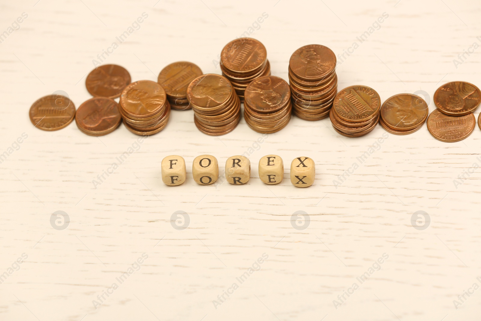 Photo of Word Forex with cubes and stacked coins on white wooden table