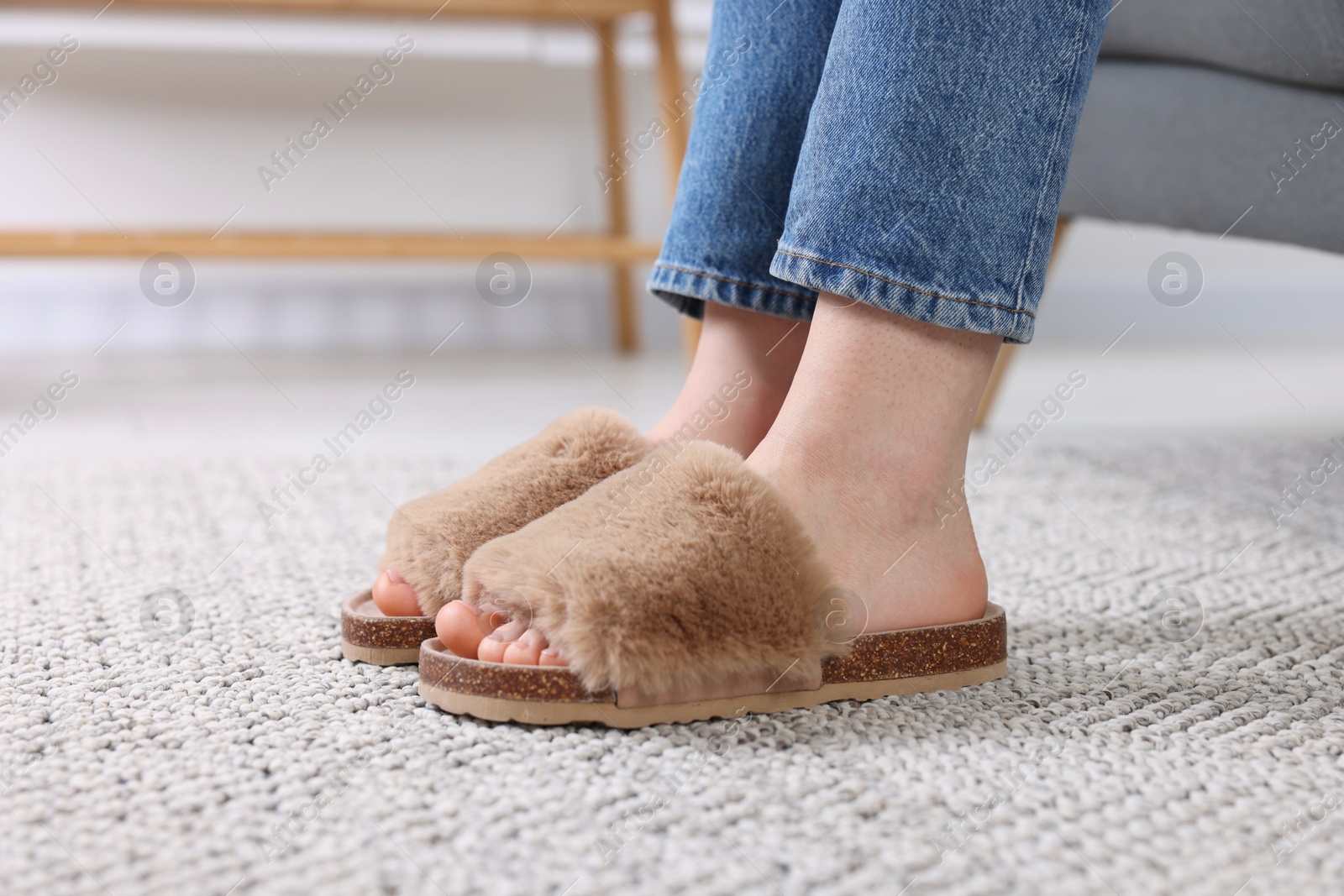 Photo of Woman in brown soft slippers at home, closeup