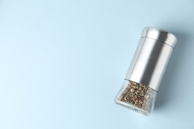 Photo of Pepper shaker on light background, top view. Space for text