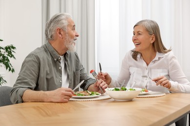 Photo of Happy senior couple having dinner at home