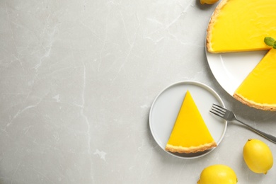 Photo of Delicious homemade lemon pie on light grey marble table, flat lay. Space for text