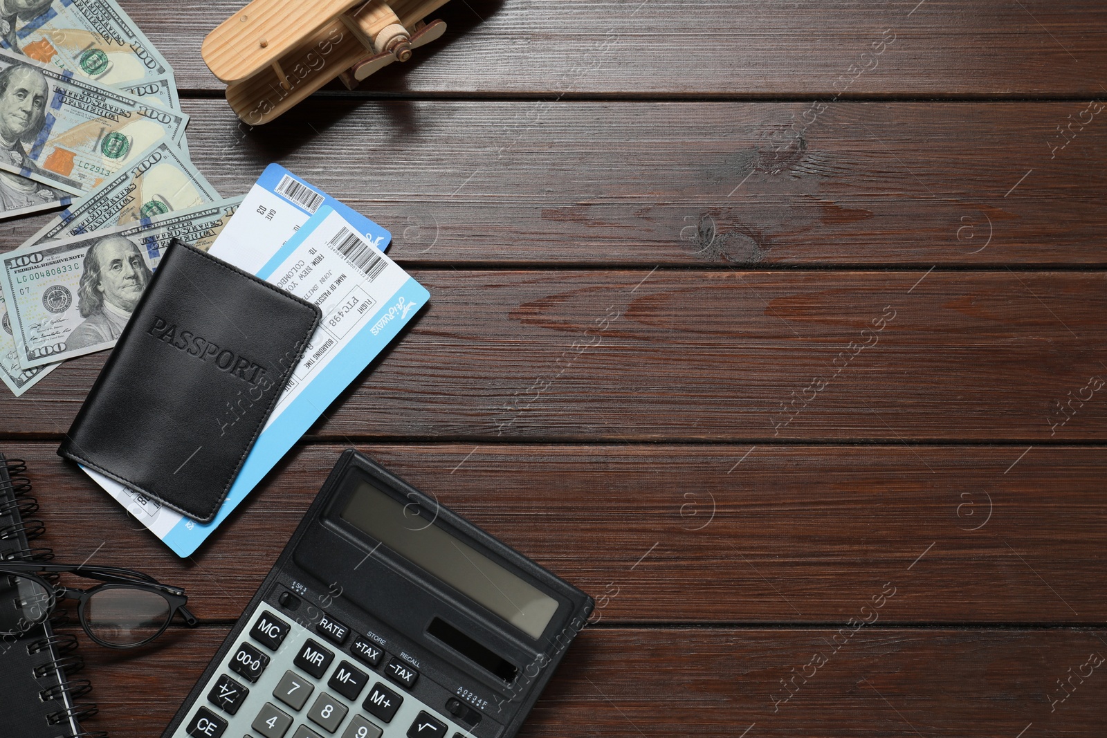 Photo of Flat lay composition with tickets, passport and dollars on wooden table, space for text. Business trip