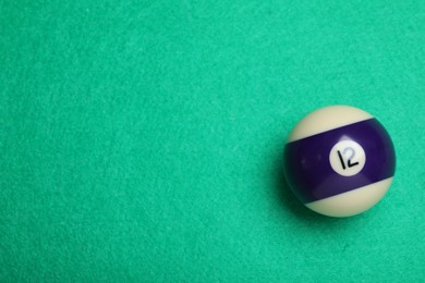 Photo of Billiard ball with number 12 on green table, top view. Space for text