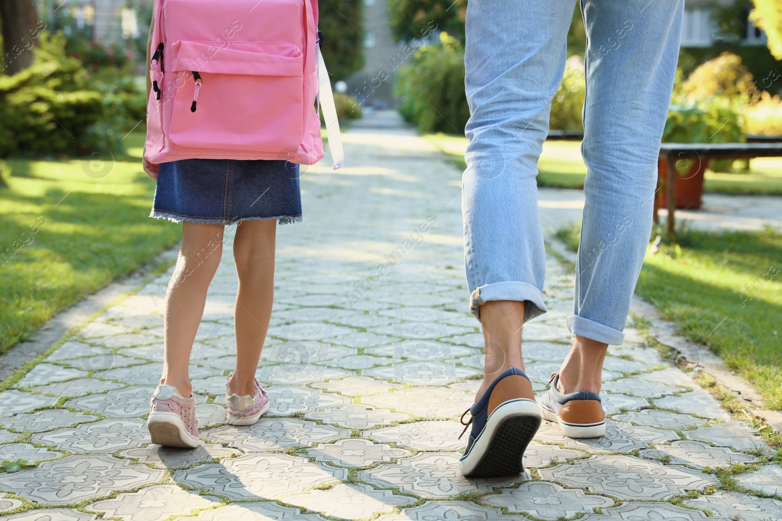 Photo of Father taking his little child to school through park, closeup