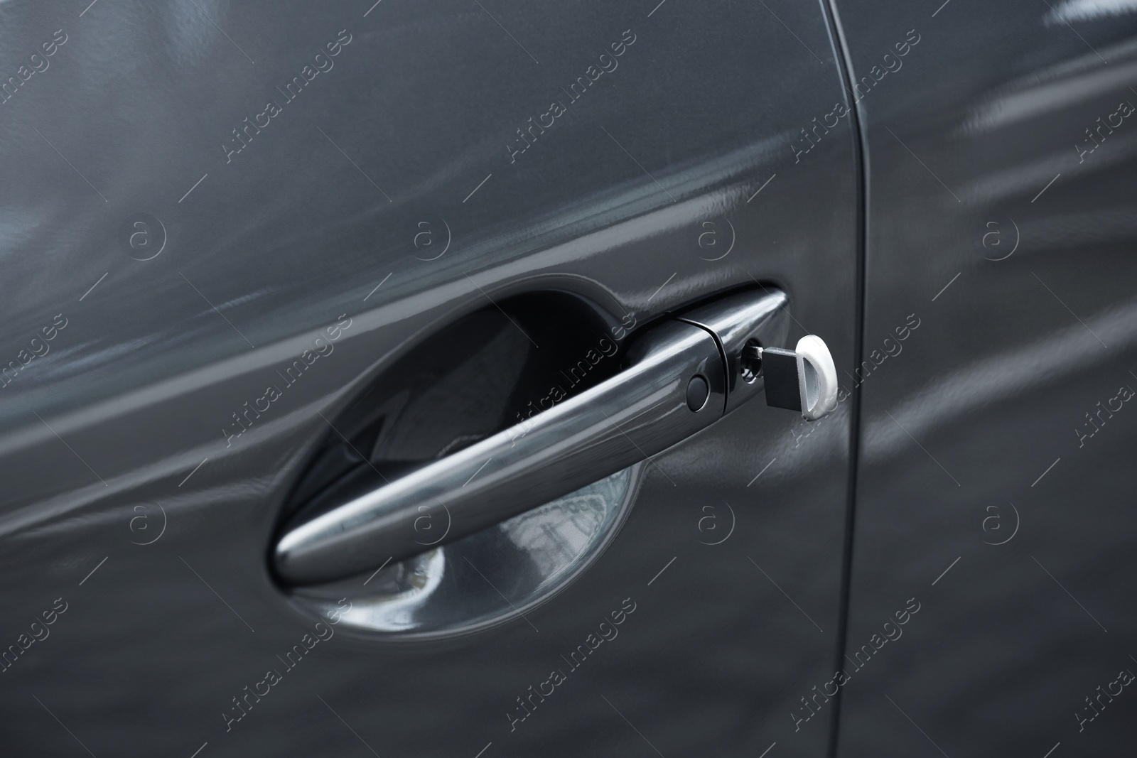 Photo of Closeup view of car door with key in lock