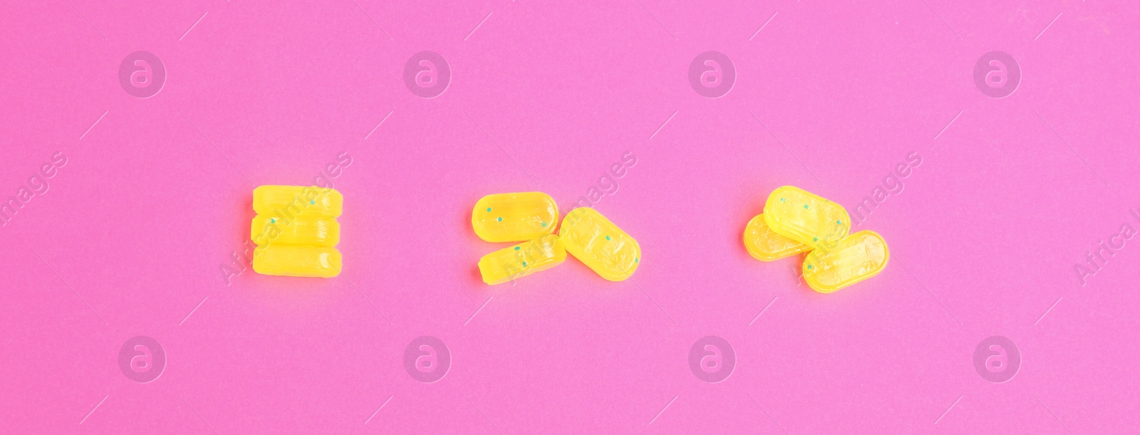 Photo of Tasty lemon drops on pink background, flat lay