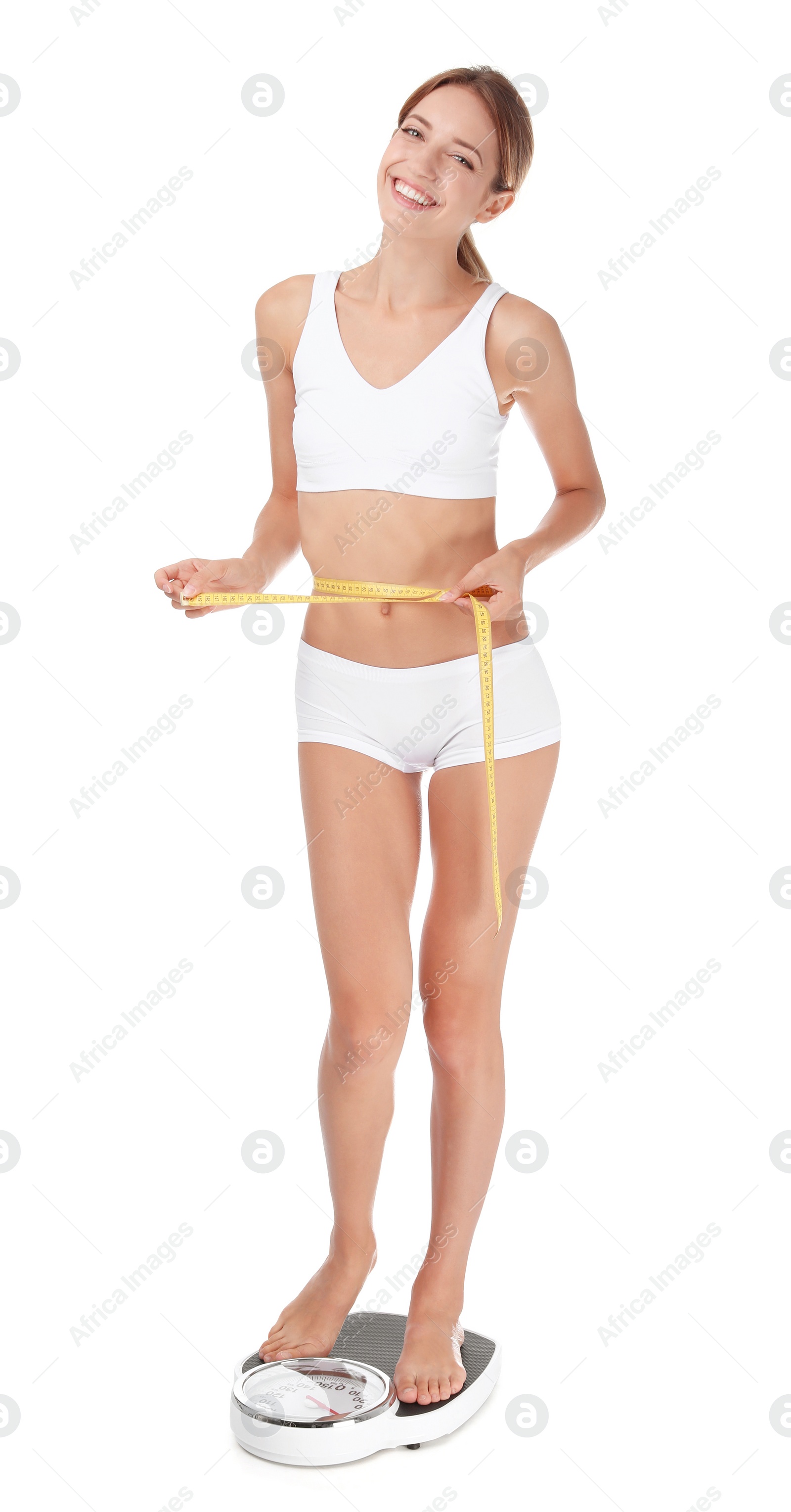 Photo of Happy slim woman with measuring tape and bathroom scales on white background. Weight loss diet results