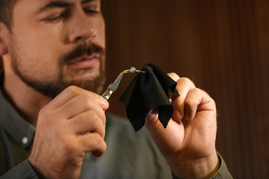 Photo of Jeweler working with ring on blurred background, closeup