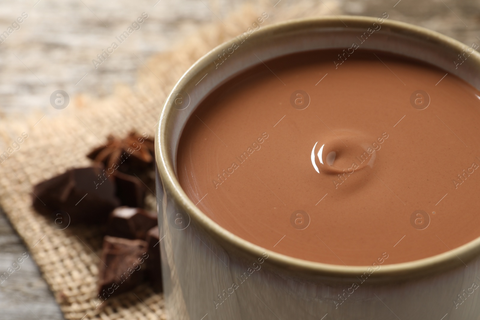 Photo of Yummy hot chocolate in mug on table, closeup