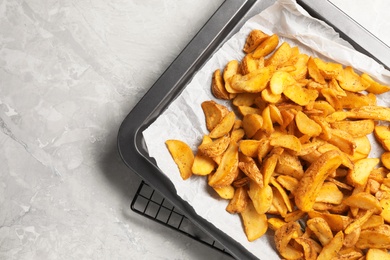 Photo of Sheet pan with delicious oven baked potatoes on marble background, flat lay. Space for text