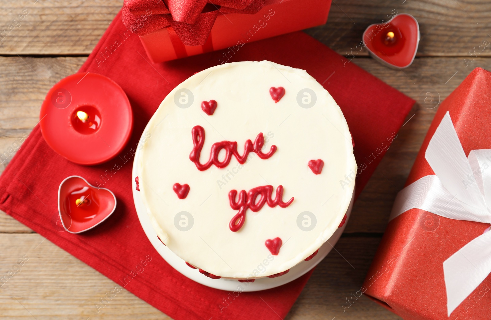 Photo of Bento cake with text Love You, candles and gift boxes on wooden table, flat lay. St. Valentine's day surprise