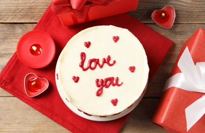 Photo of Bento cake with text Love You, candles and gift boxes on wooden table, flat lay. St. Valentine's day surprise