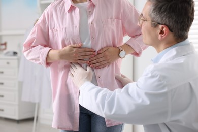Gastroenterologist examining patient with stomach pain in clinic