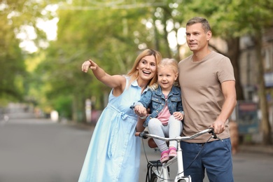 Photo of Happy family with bicycle outdoors on summer day