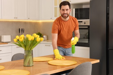 Photo of Spring cleaning. Man tidying up kitchen at home