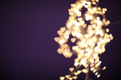 Photo of Blurred view of beautiful lights on purple background, space for text. Bokeh effect