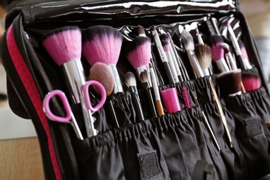 Photo of Beautician case with professional makeup products and tools, closeup