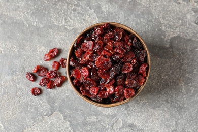 Photo of Bowl with sweet cranberries on color background, top view. Dried fruit as healthy snack