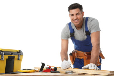 Handsome carpenter working with timber at wooden table on white background