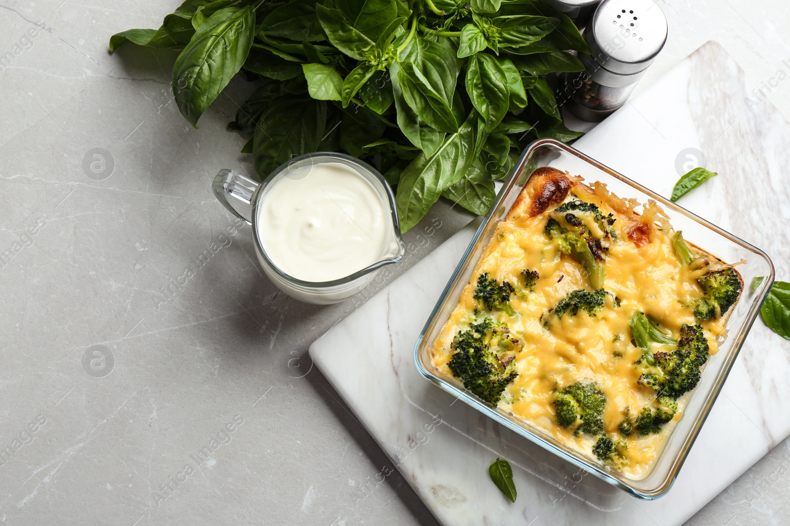 Photo of Flat lay composition with tasty broccoli casserole on grey marble table