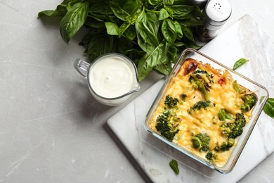 Photo of Flat lay composition with tasty broccoli casserole on grey marble table