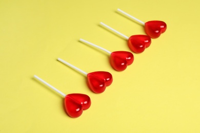 Photo of Sweet heart shaped lollipops on yellow background. Valentine's day celebration