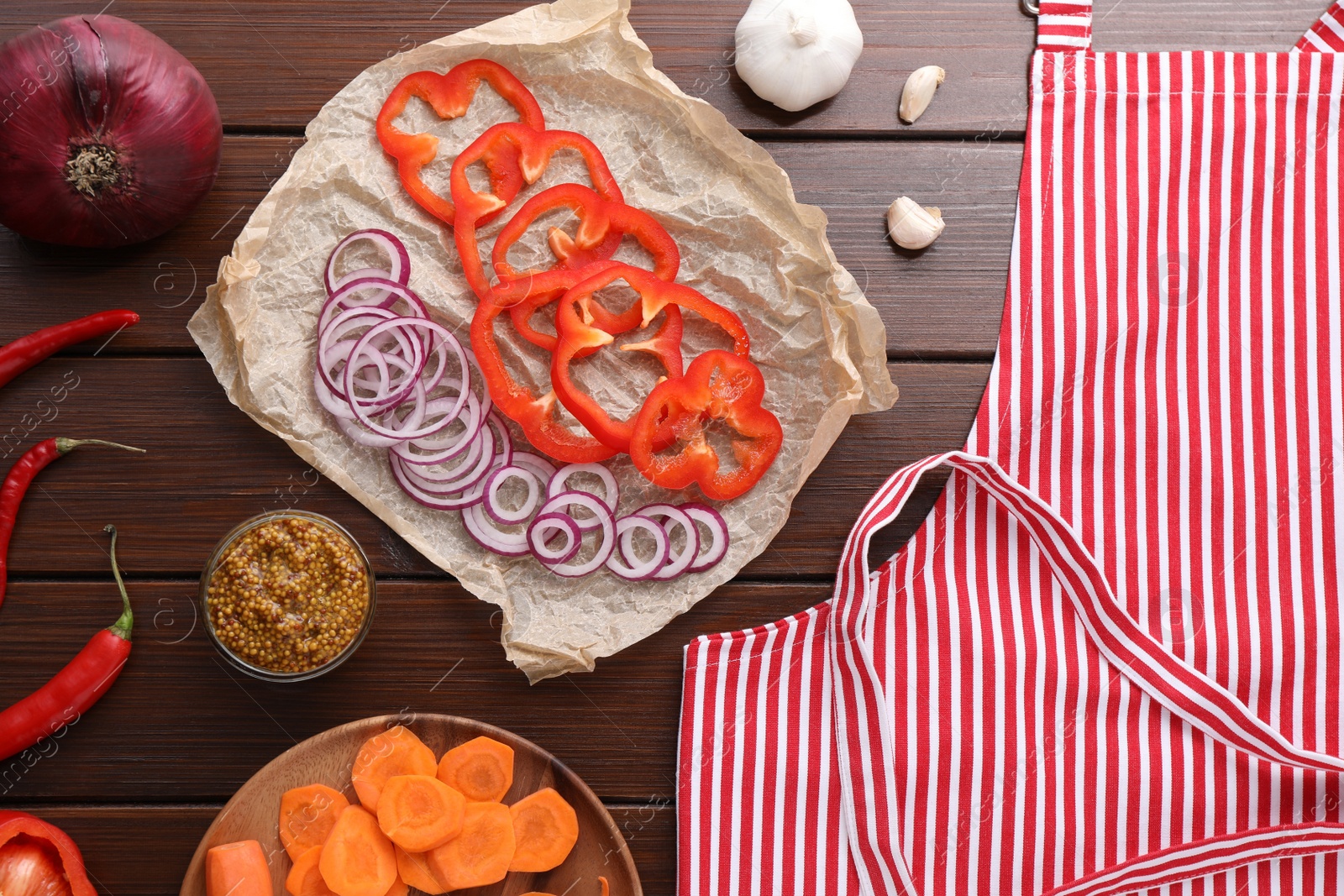 Photo of Flat lay composition with striped apron and different ingredients on wooden table