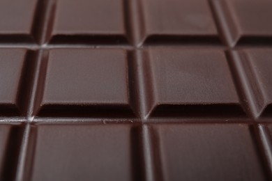 Photo of Delicious dark chocolate bar as background, closeup