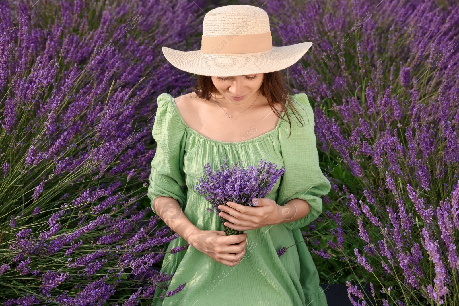 Photo of Beautiful woman with bouquet in lavender field