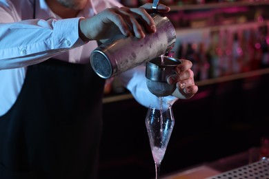 Photo of Bartender making fresh alcoholic cocktail in bar, closeup