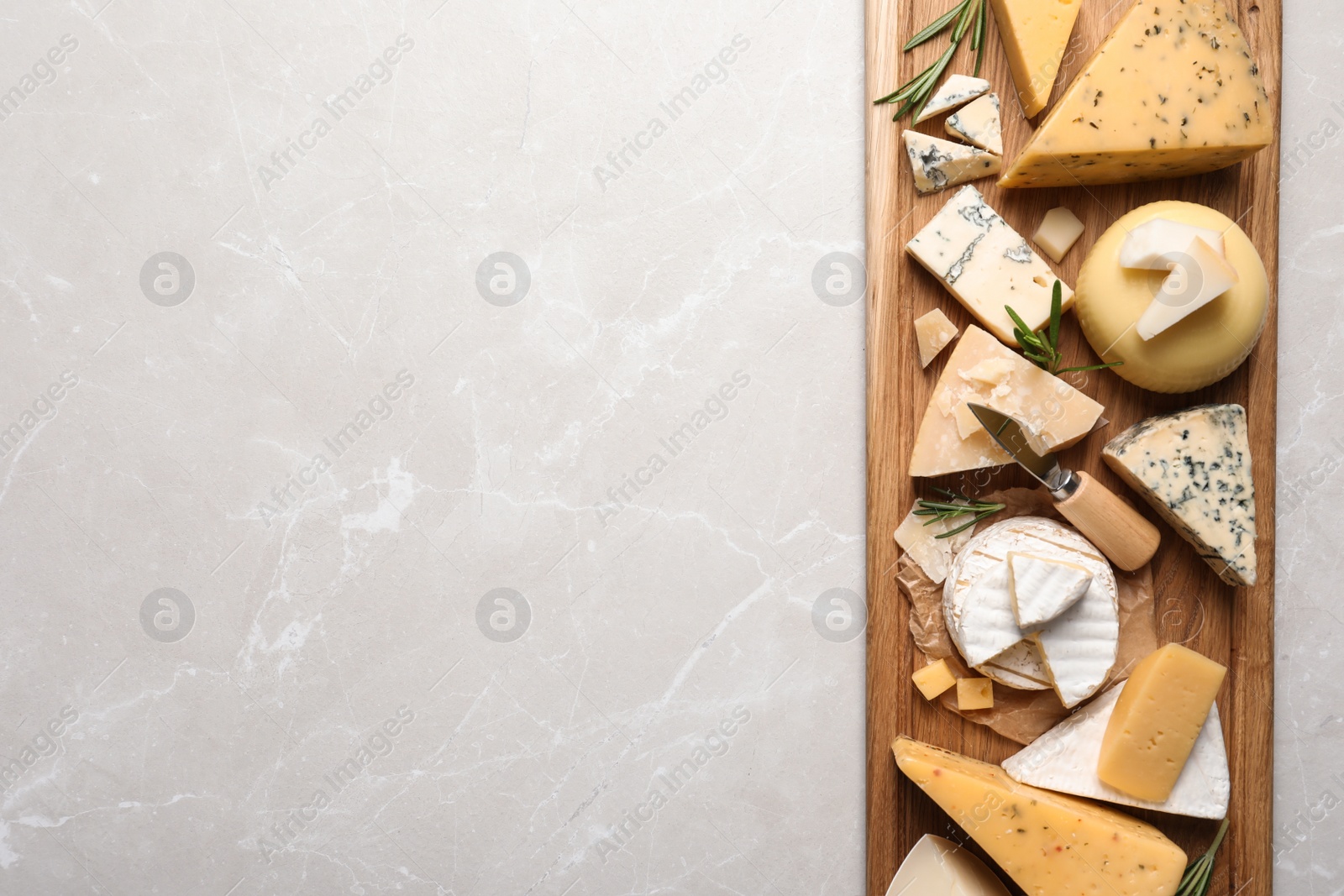 Photo of Different delicious cheeses served on grey table, top view. Space for text