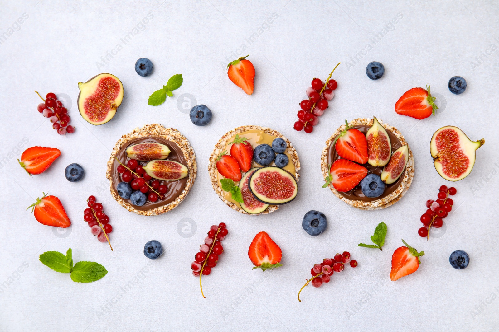 Photo of Flat lay composition with tasty crispbreads and berries on light table