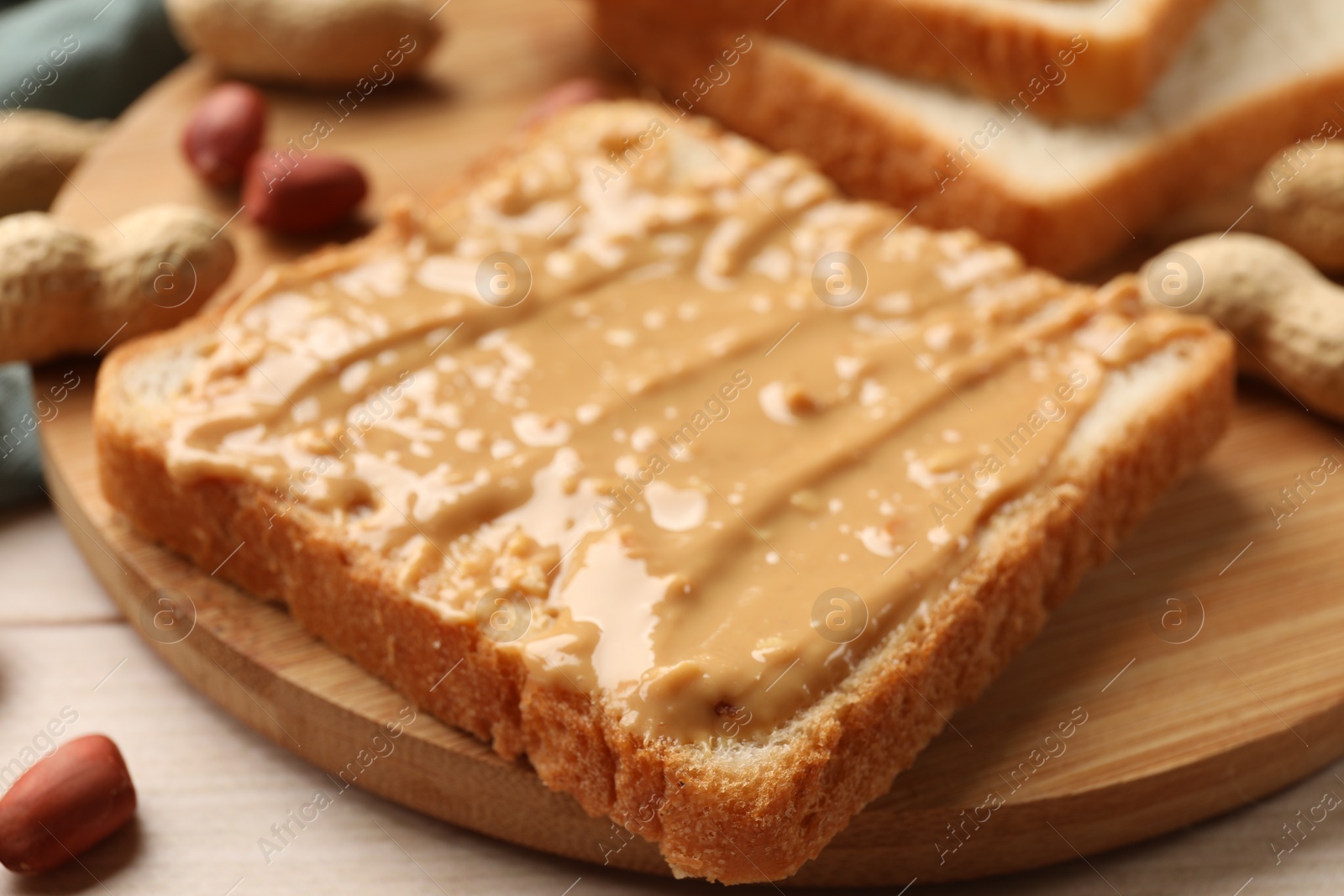 Photo of Delicious toast with peanut butter on table, closeup