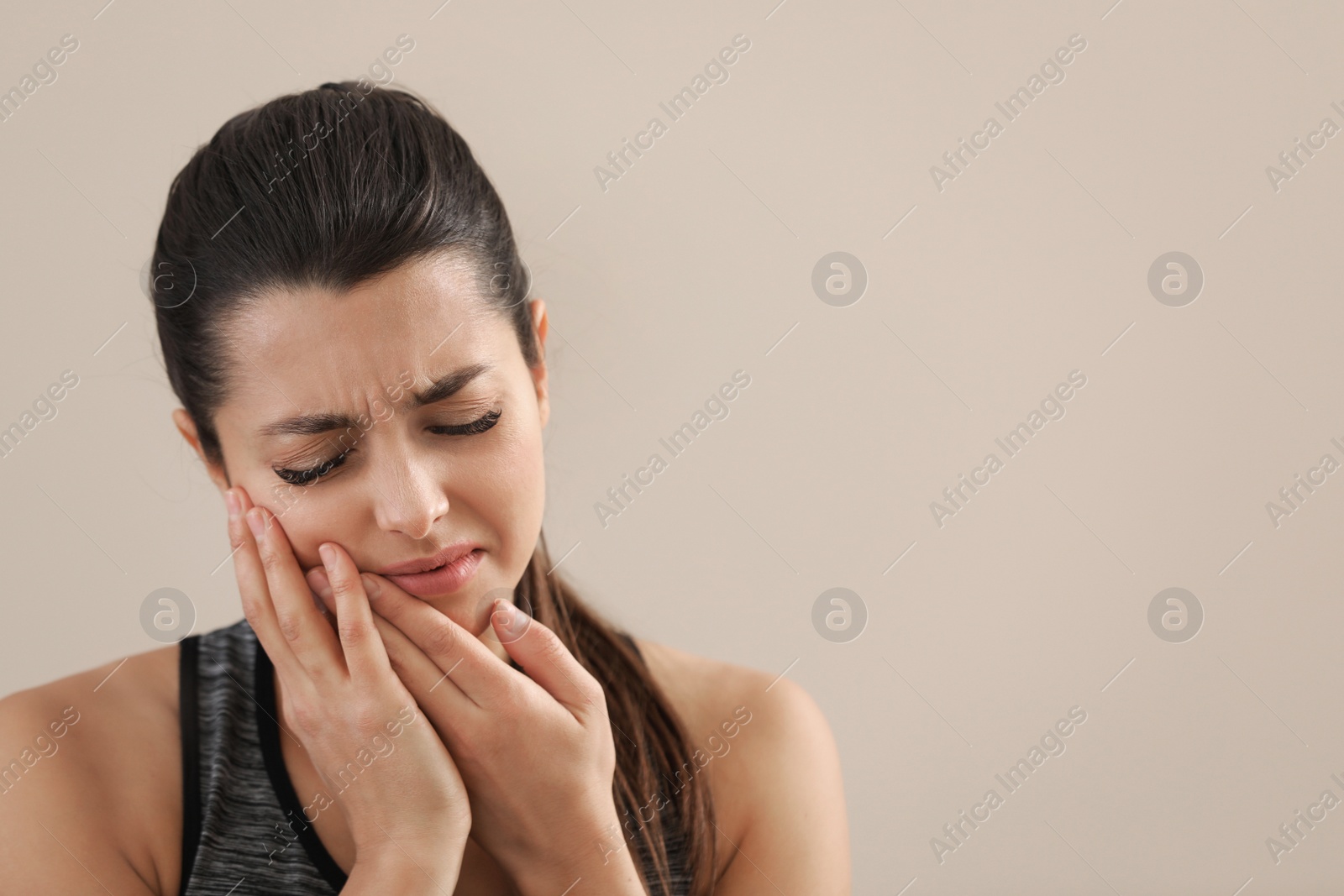 Photo of Young woman with sensitive teeth on color background. Space for text