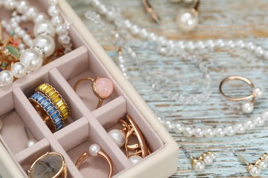 Photo of Jewelry box with many different accessories on rustic wooden table, closeup
