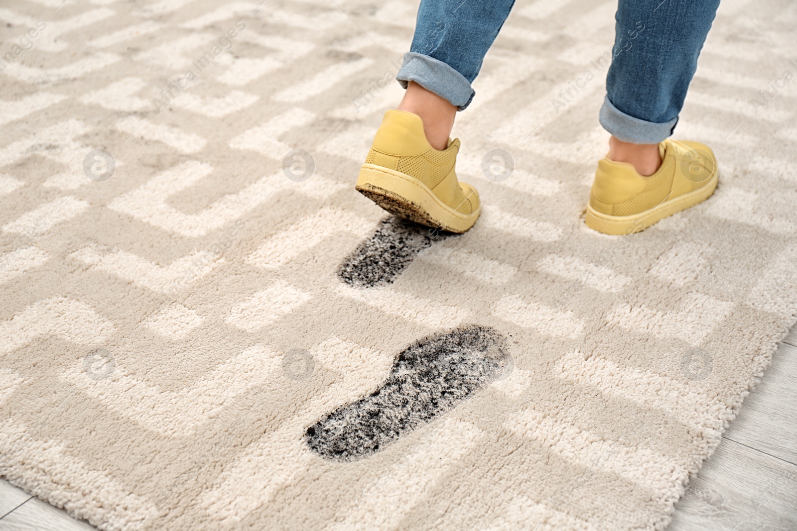 Photo of Person in dirty shoes leaving muddy footprints on carpet